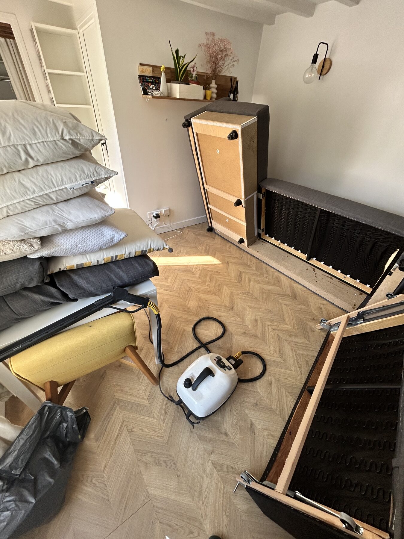 Intervention vapeur en cours dans une chambre, sommier démonté